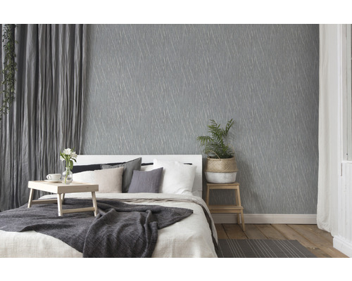 Slaapkamer met grijs behang, bed en decoraties