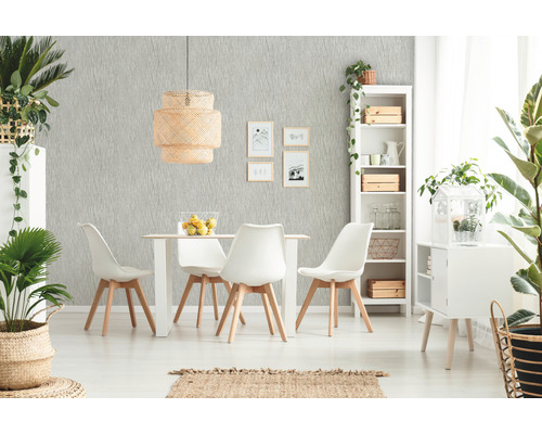 Lichte eetkamer met eettafel, stoelen, rotan lamp en decoratieve planten