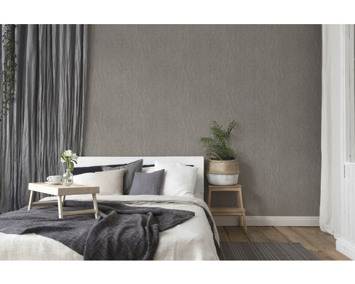 Slaapkamer met patroonbehang, bed en gordijnen voor een gezellige sfeer