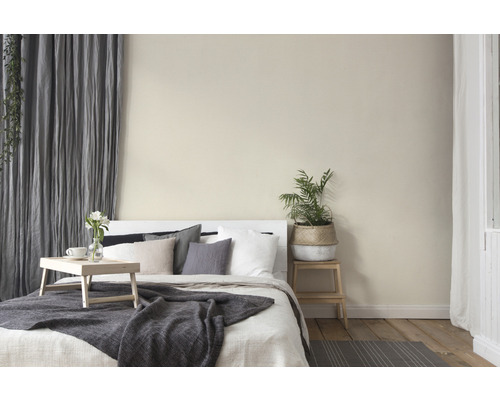 Lichte slaapkamer met bed, kussens, deken, gordijnen en kamerplant voor een gezellige sfeer