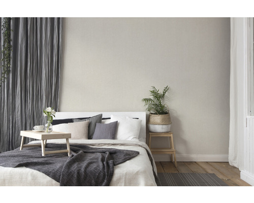 Slaapkamer met bed, kussens, sprei, gordijnen en kamerplant voor een gezellige sfeer.