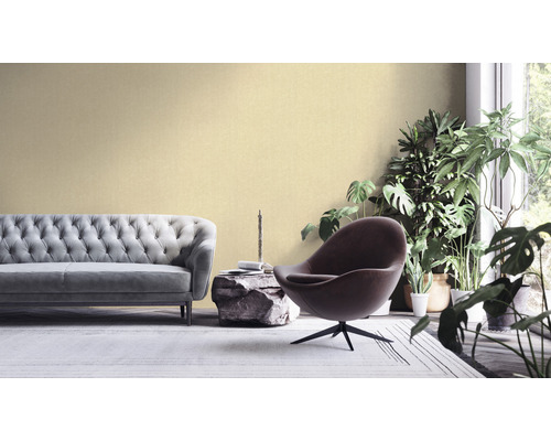 Woonkamer met bank, fauteuil en kamerplanten voor een vriendelijke sfeer.