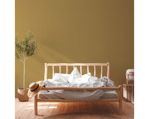 Slaapkamer met houten bed, kamerplant, strohoed en houten vloer