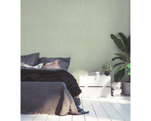 Slaapkamer met bed, nachtkastje, kamerplanten en effen behang