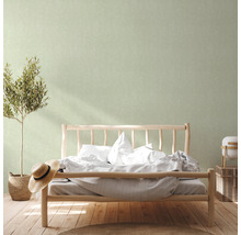 Slaapkamer met houten bed, plant, hoed en decoratieve wand
