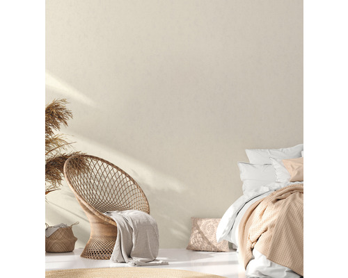 Lichte slaapkamer met rotan stoel, bed en decoratieve elementen voor een vriendelijke sfeer.