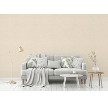 Woonkamer met een gestructureerd behang in een heldere kleur, een bank, een tafel en een vloerlamp.