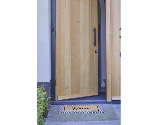 Open voordeur met deurmat met het woord thuis