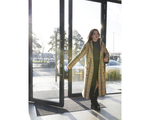 Entree met deurmat en een vrouw die een deur opent