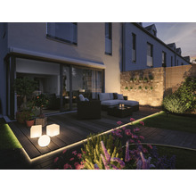 Verlicht terras met tuinmeubelen, planten en decoratieve buitenverlichting