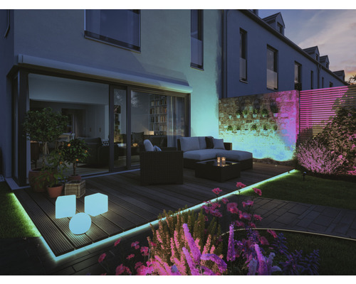 Buitenruimte met tuinmeubilair en decoratieve buitenverlichting.