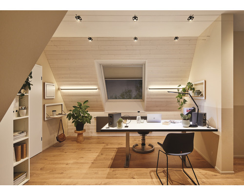Lichte zolderkamer met bureau, rek en verlichtingssysteem
