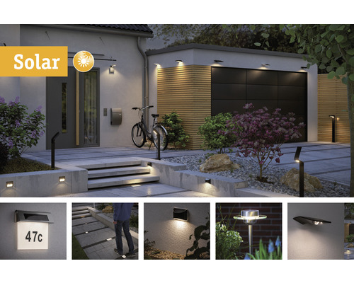 Buitenkant met solarlampen aan de muur, garage en het pad