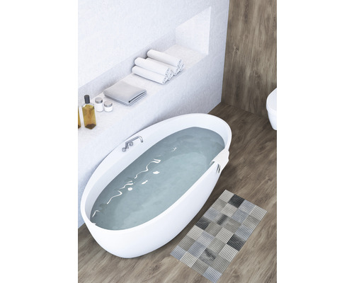 Badkamer met vrijstaand bad, handdoeken en badmat