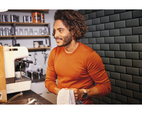 Man in keuken met spoelbak, koffiezetapparaat en afwasrek