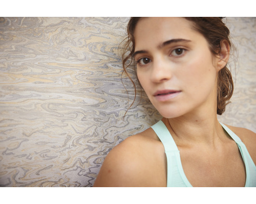 Vrouw voor een behang met marmerstructuur