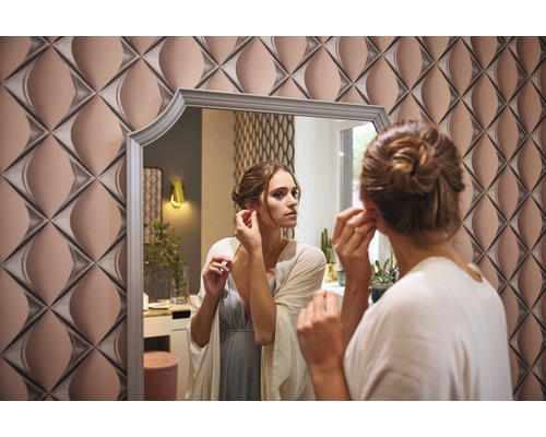 Vrouw voor een spiegel met geometrisch wandpaneel op de achtergrond