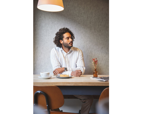 Man zit aan een tafel met een drankje en een gebakje.