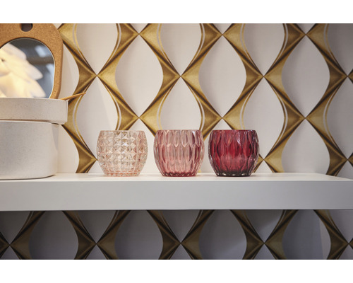 Drie theelichthouders van glas op een plank