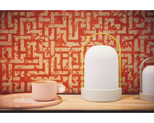 Decoratieve tafellamp met handvat en patroonbehang op de achtergrond