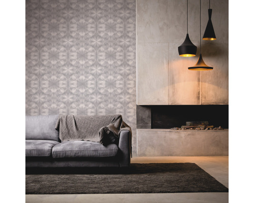 Woonkamer met patroonbehang, bank, vloerkleed, open haard en hanglampen