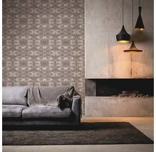Woonkamer met patroonbehang, bank, vloerkleed, open haard en hanglampen