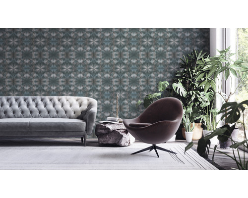 Woonkamer met bank, stoel, kamerplanten en behang met patroon