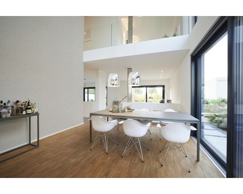 Lichte woonkamer met eettafel, stoelen en groot raam