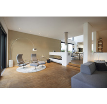 Lichte woonkamer met fauteuils, staande lamp en open haard