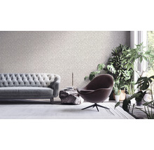 Woonkamer met patroonbehang, bank, fauteuil en kamerplanten