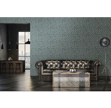 Woonkamer met leren bank, staande lamp en behang met patroon