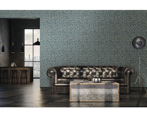 Woonkamer met leren bank, staande lamp en behang met patroon