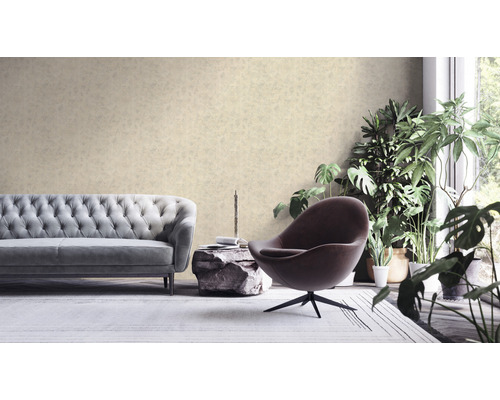 Woonkamer met bank, fauteuil en kamerplanten voor een patroonbehang.