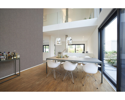 Lichte woonkamer met eettafel, stoelen en behang met patroon