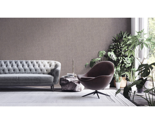 Woonkamer met bank, fauteuil en behang met patroon