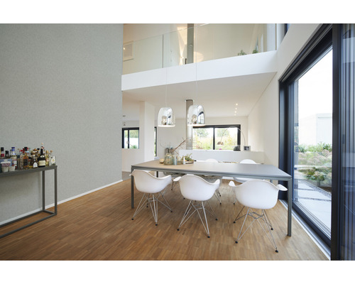 Lichte woonkamer met eettafel, stoelen en groot raam