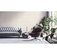Woonkamer met bank, fauteuil en planten voor een lichte en vriendelijke sfeer.
