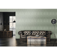 Woonkamer met leren bank, salontafel en behang met motief