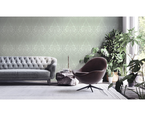 Woonkamer met bank, fauteuil, kamerplanten en behang met patroon