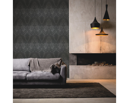 Woonkamer met behang met motief, bank, tapijt en hanglampen