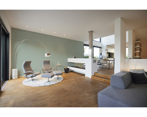 Lichte woonkamer met fauteuils, open haard en houten vloer