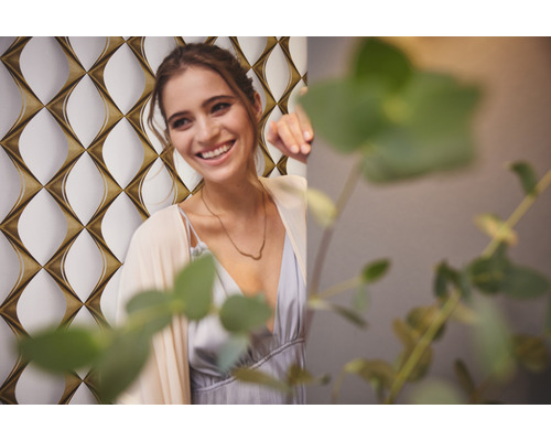 Vrouw lacht voor een behang met patroon