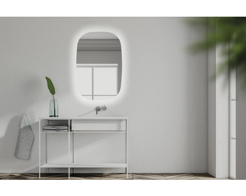 Badkamer met verlichte spiegel, wastafel, kraan en decoratie.