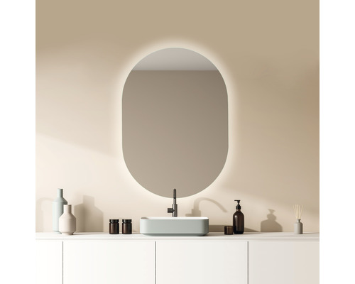 Badkamer met ovale spiegel, waskom en armaturen op een witte wastafel