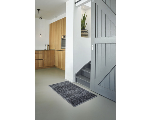 Interieur met vloerkleed, trap en houten keuken