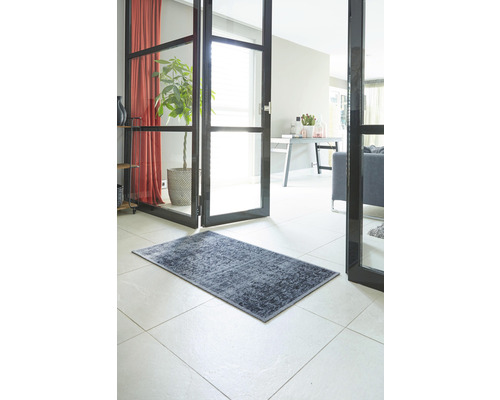 Decoratief tapijt in de hal van een huis op een tegelvloer.