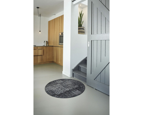 Interieur met rond vloerkleed, keuken en trap.