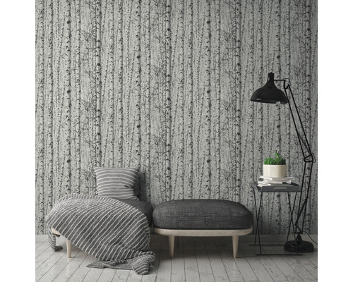 Woonkamer met behang met berkenpatroon, fauteuil, kruk en staande lamp