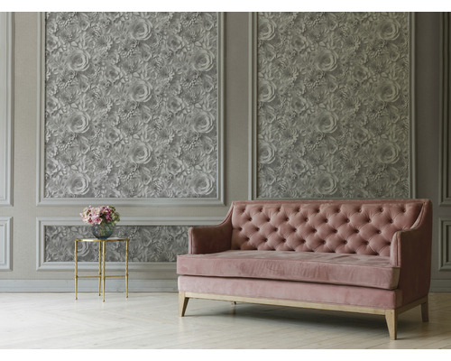 Woonkamer met bloemenbehang, bank en bijzettafel.