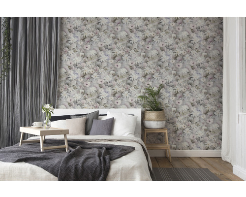 Slaapkamer met bloemenbehang, bed en gordijnen voor een gezellige sfeer.
